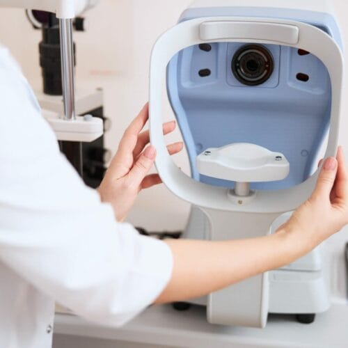 Physician putting an autorefractor rest into a right position