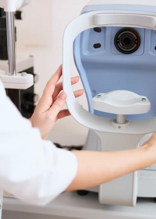 Physician putting an autorefractor rest into a right position